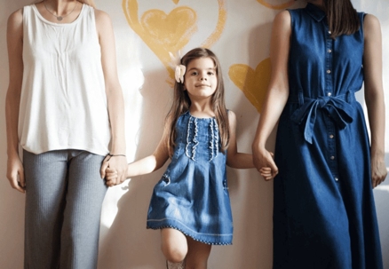 Same-sex couple holding hands with their daughter